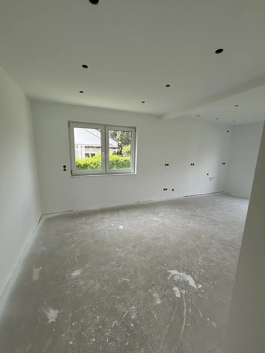 Derselbe Raum mit glatten weißen Wänden und neuer Spotdecke nach dem Ausbau