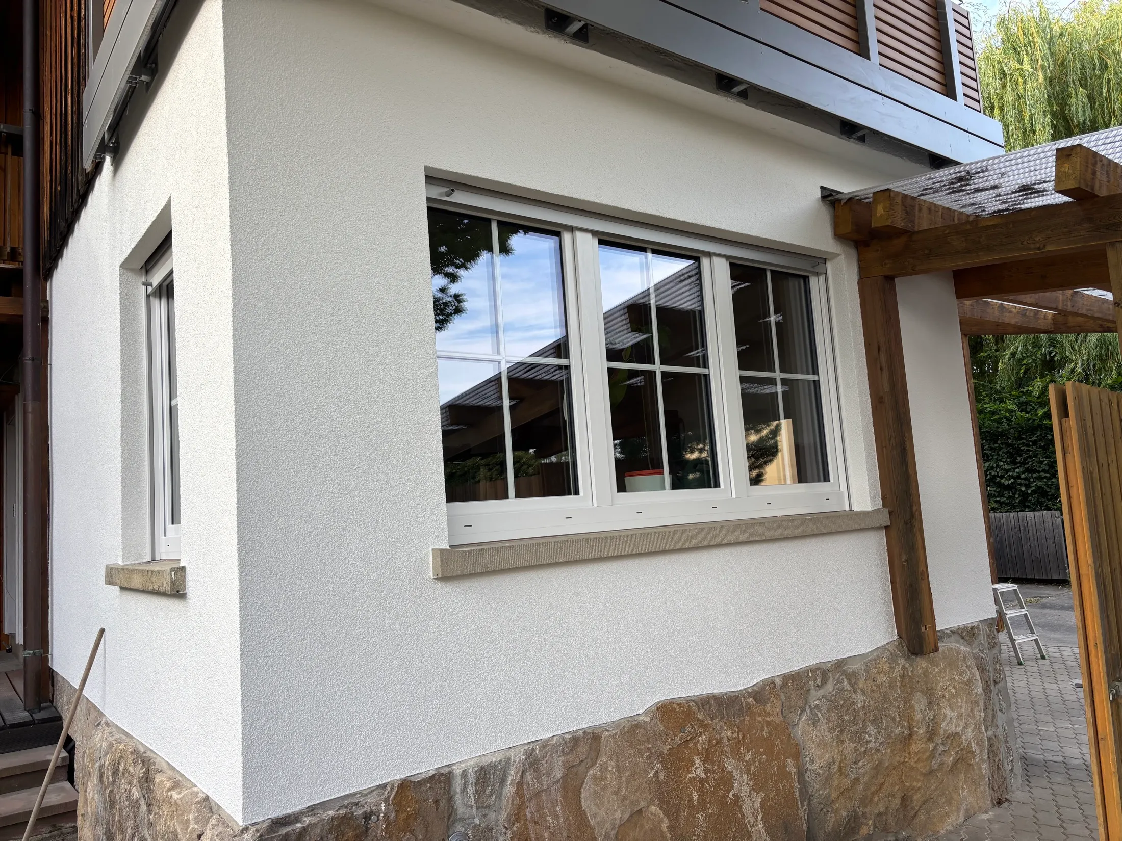 Detailansicht der fertig gestrichenen weißen Fassade mit neuem Sprossenfenster