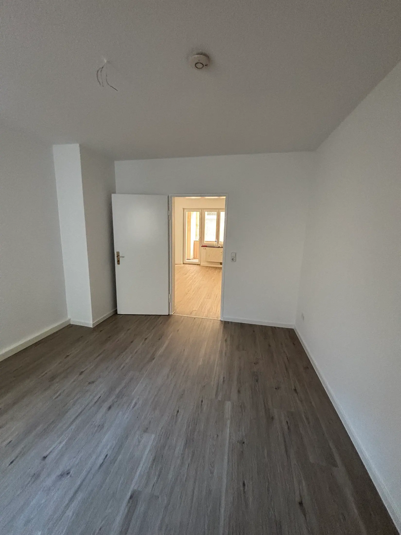 Frisch renovierte Wohnung mit neuem Bodenbelag und weiß gestrichenen Wänden vor der Neuvermietung